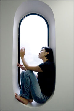 A person sitting in a long tall window