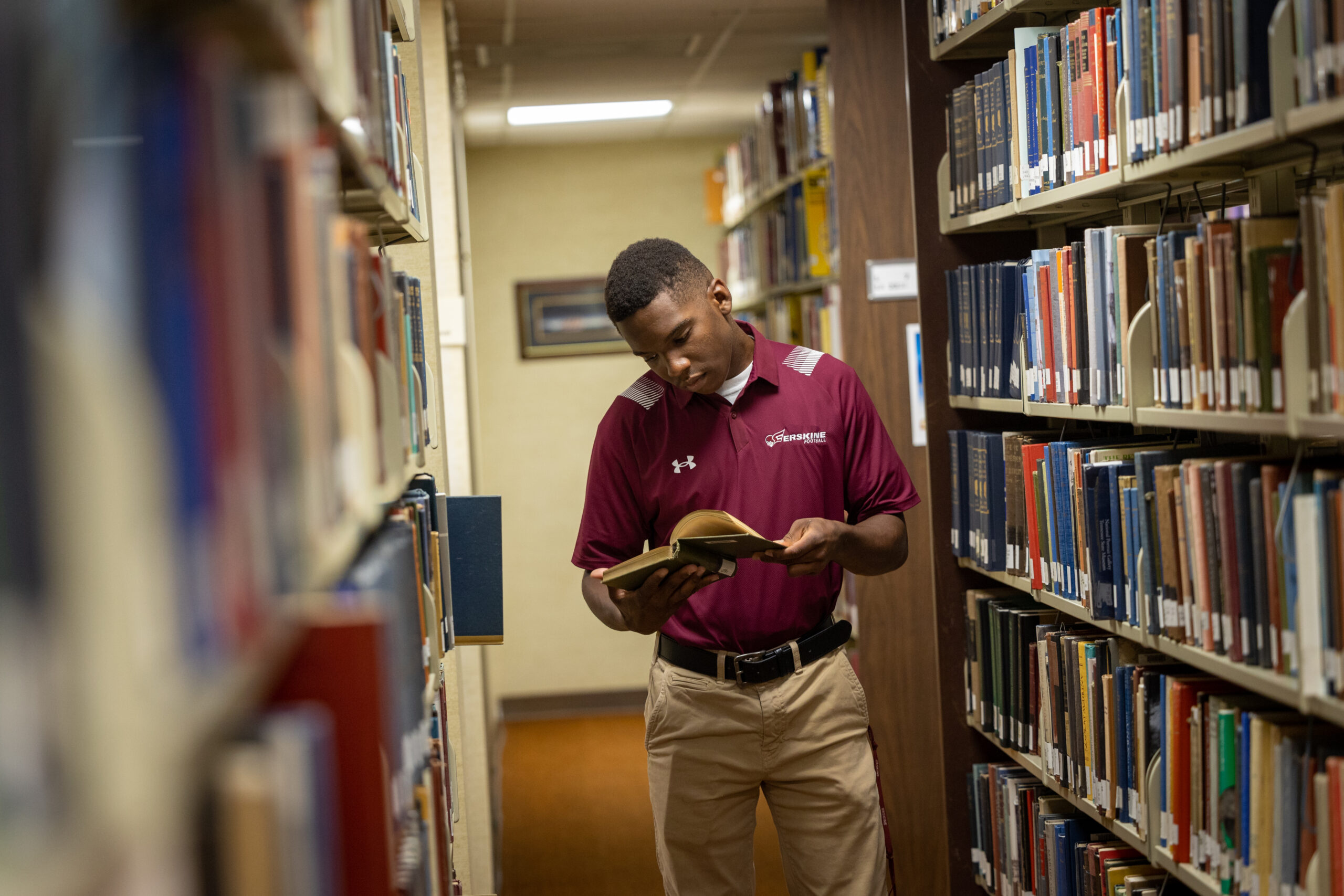 A student browses the library shelves