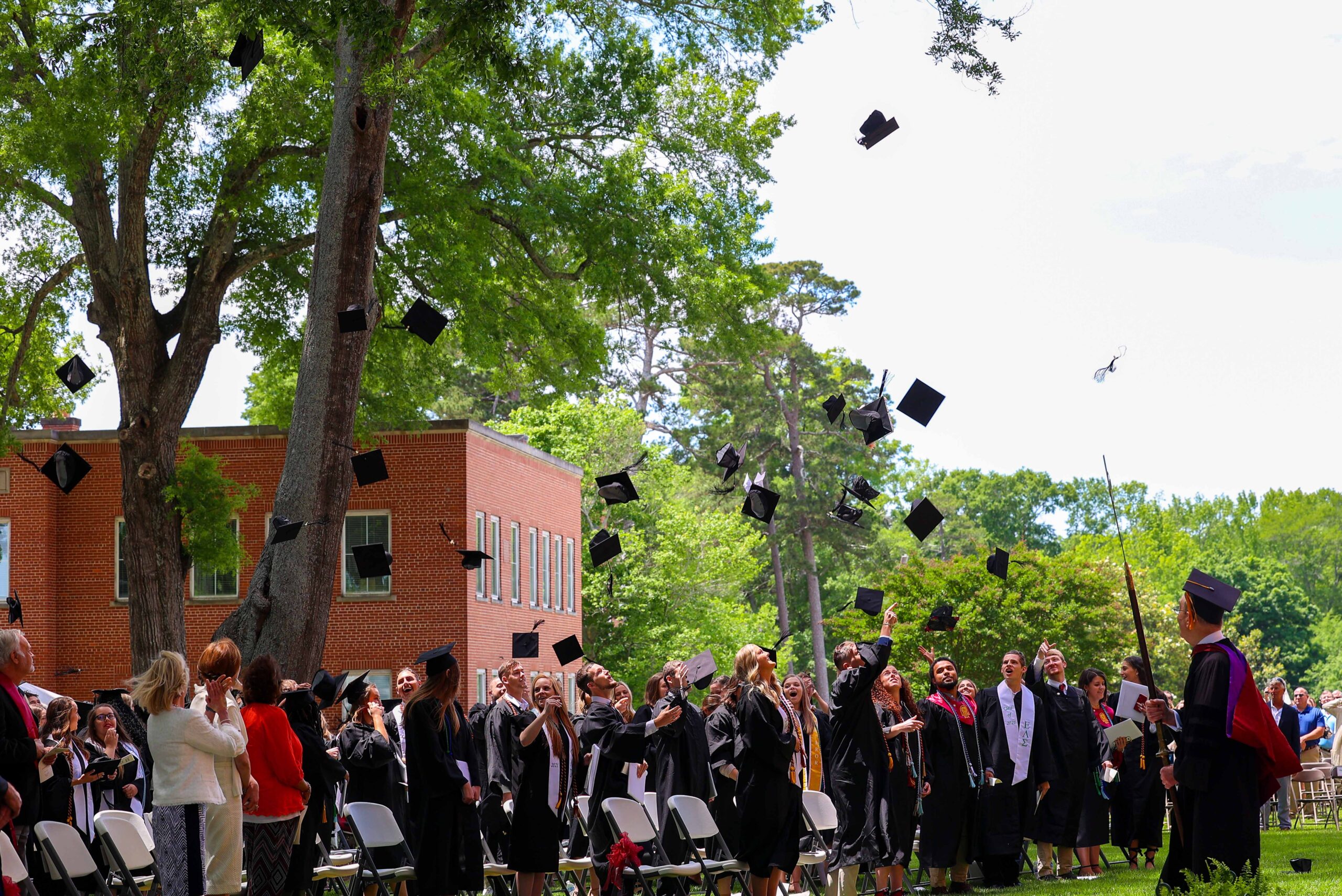 Students throw their caps after commencement