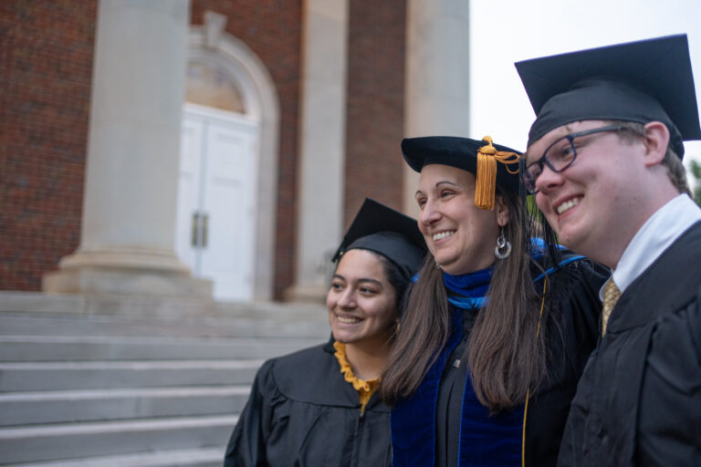 Erskine professor Briana Van Scoy poses at baccalaureate with two students