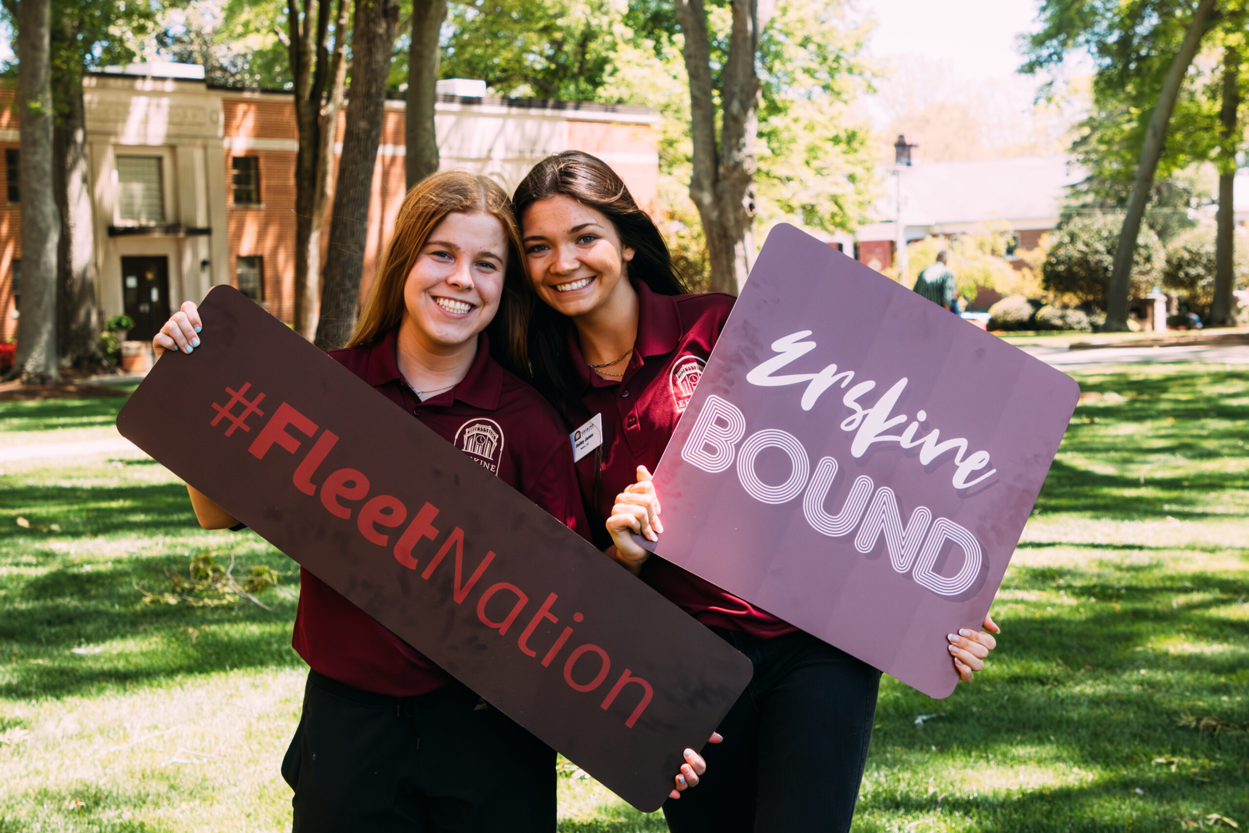 Two female students pose with Erskine Bound and Erskine Nation signs