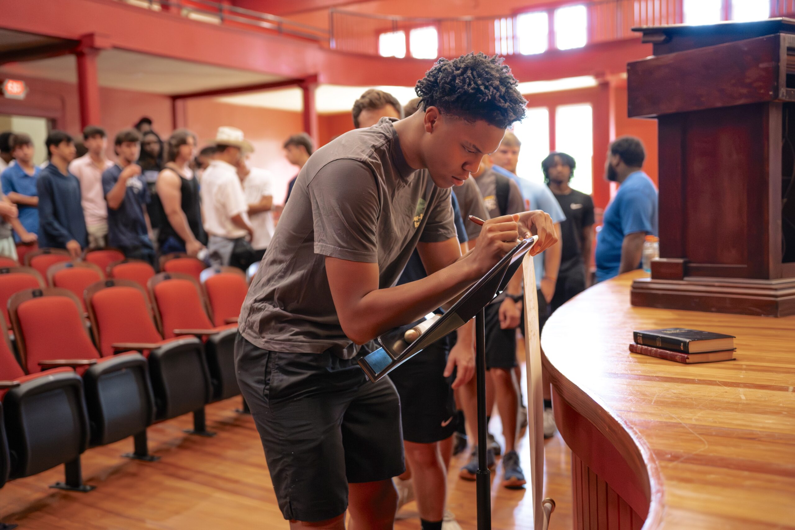 A freshman man signs the scroll