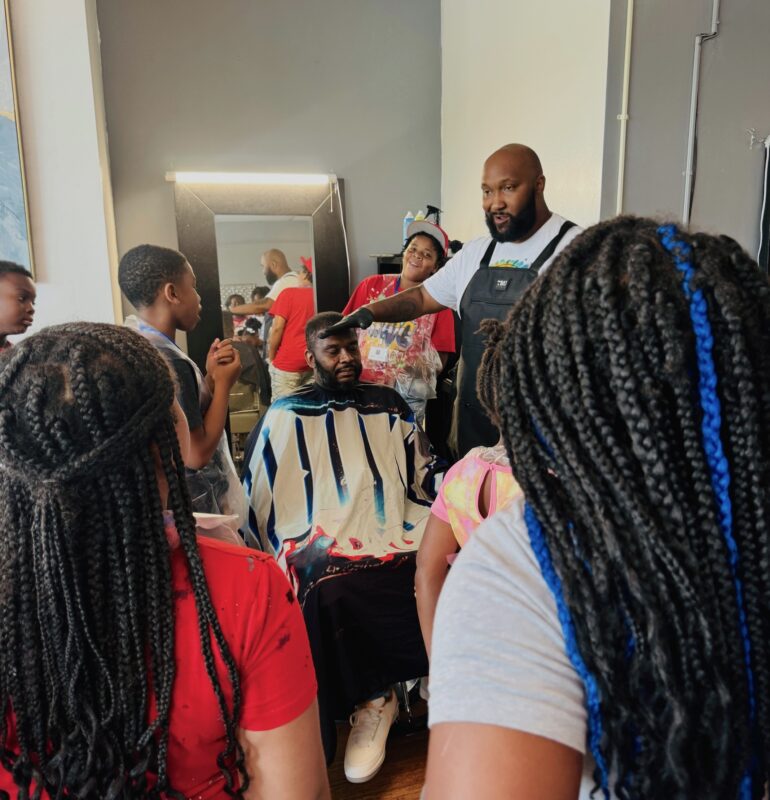 Demarco Ryan, seated, takes part in a demonstration by Dorian Ross of Cutz by Mike.