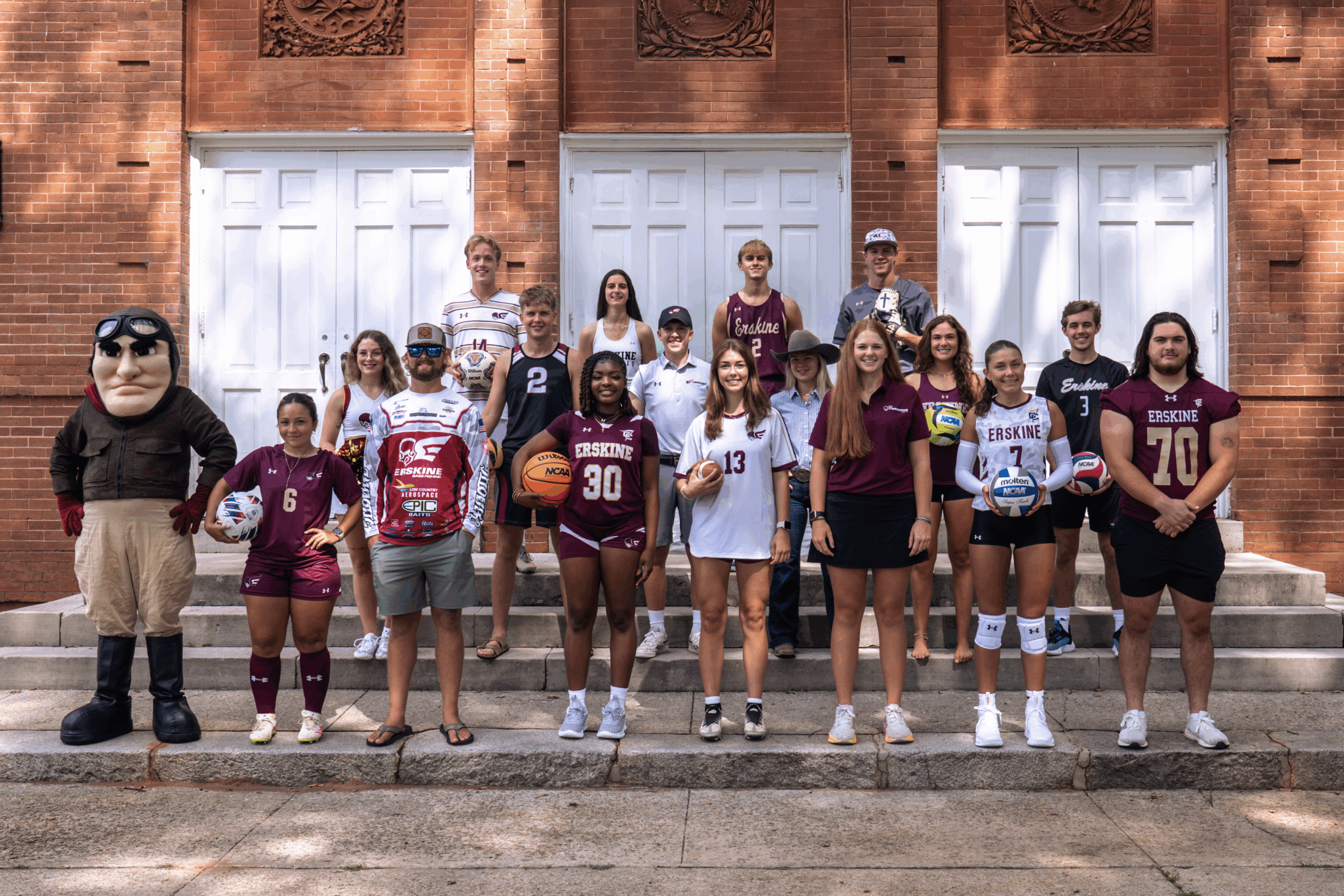 Members of Erskine Athletics pose in front of the Erskine Building
