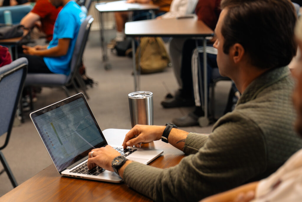 Student with a laptop in a classroom