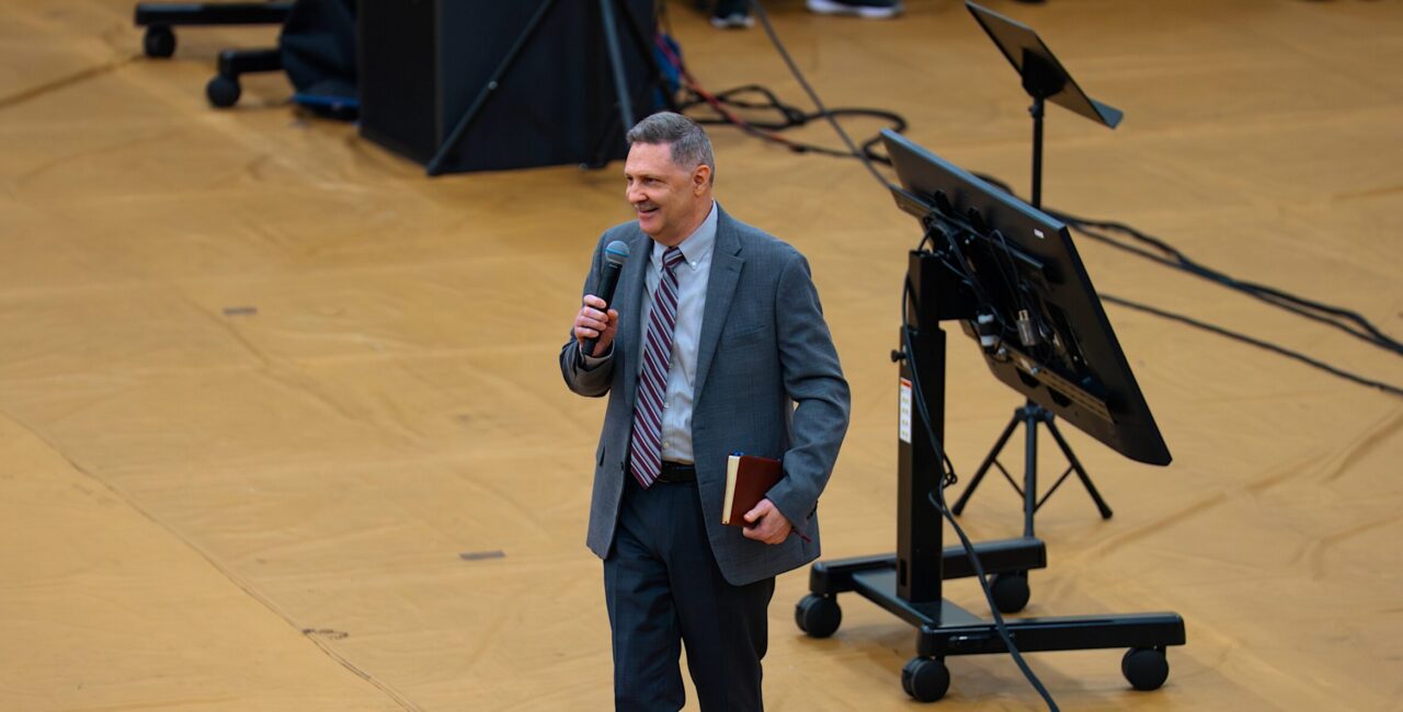 Bible in hand, Dr. Adamson addresses students at Fleet Fellowship.