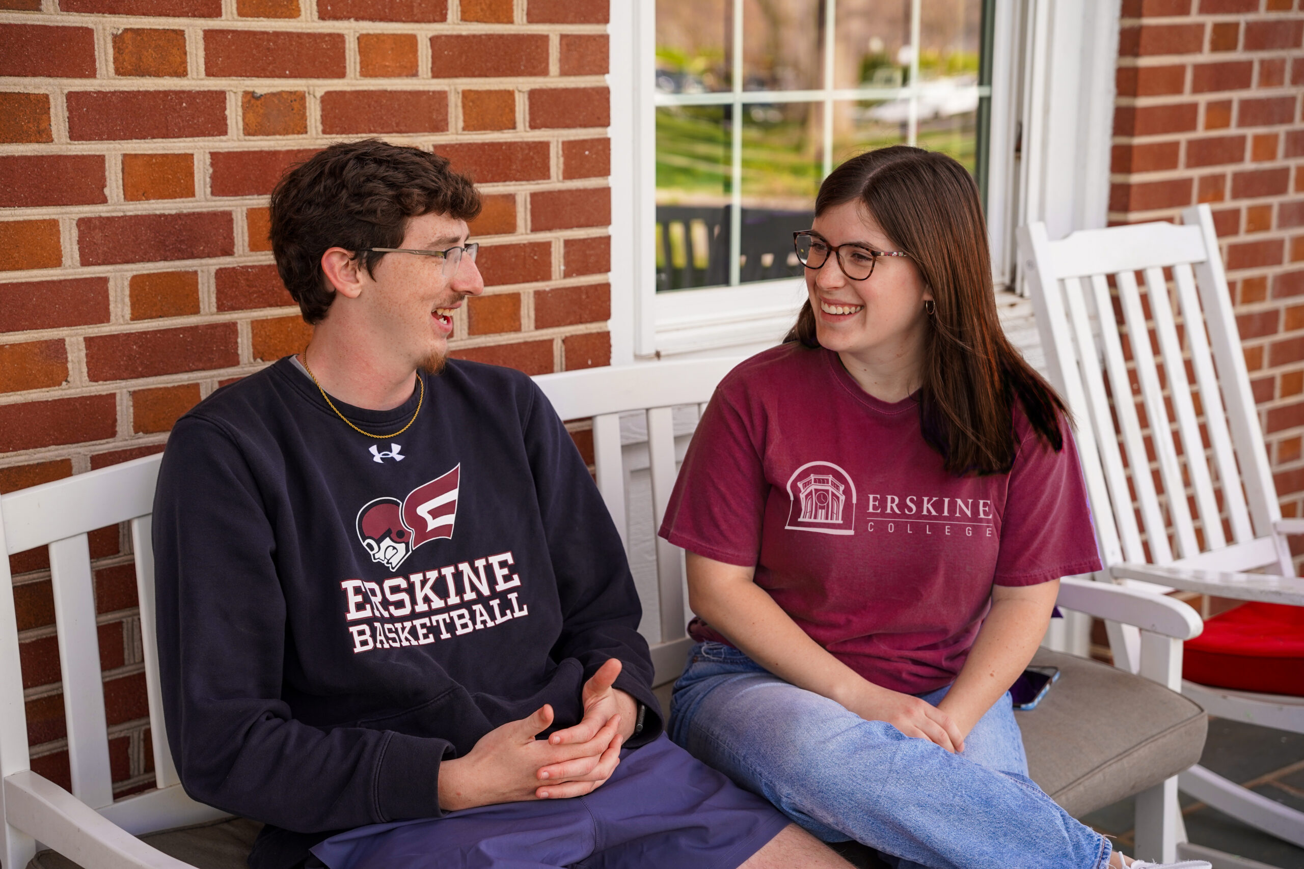 Two students talk on the porch of Watkins Student Center
