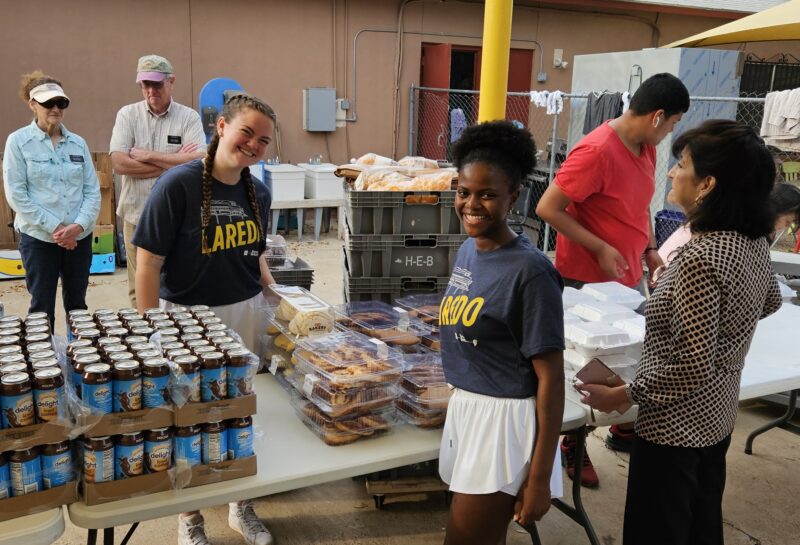 Two members of the Laredo mission trip team serve food