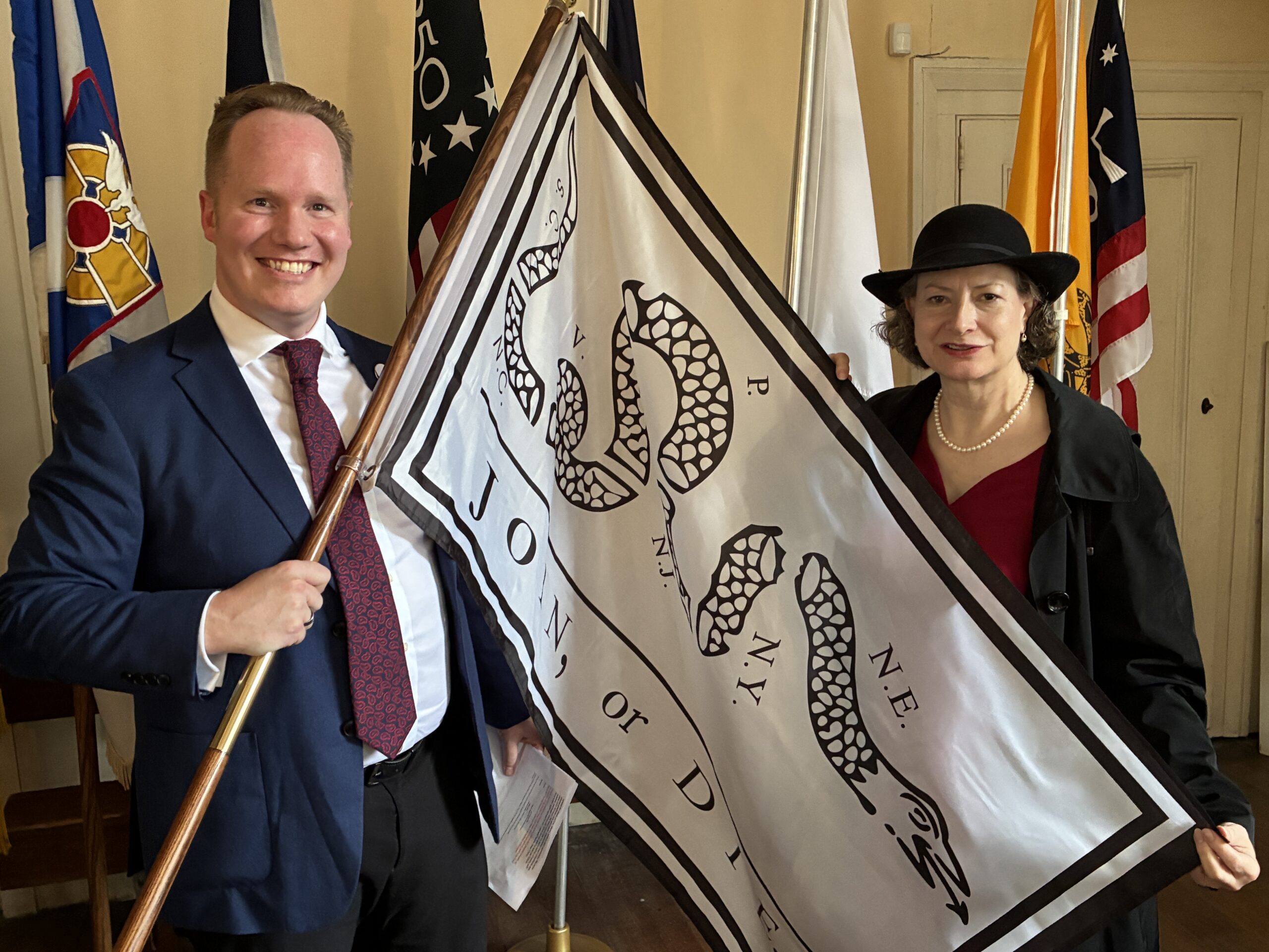 Jim and Rachel hold Join or Die flag